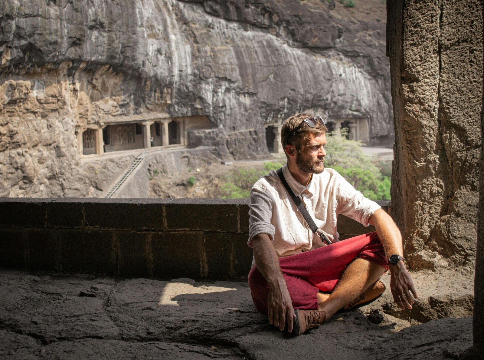 A man sitting in meditation at the historic Ellora Caves, Maharashtra, India.